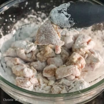 Diced raw chicken pieces coated in white cornstarch.