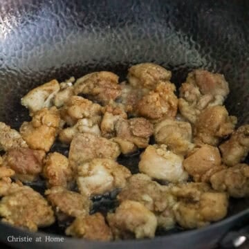 Golden brown chicken pieces frying in clear oil.