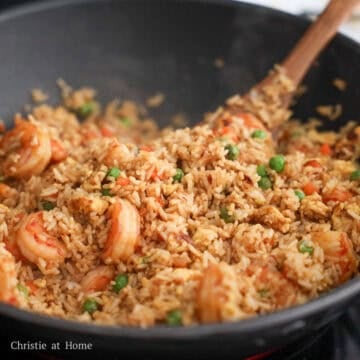 Golden jasmine rice tossed with shrimp, eggs, and green peas, evenly coated in a rich mahogany soy sauce glaze and topped with sliced green onions.
