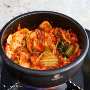 Heat vegetable oil in a small pot on medium heat. Sauté sliced onions and minced garlic until softened. Then sauté the chopped kimchi for 2 minutes.