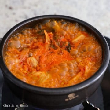 Mix in anchovy stock, kimchi brine, gochugaru, and fish sauce. Simmer uncovered for 15 minutes on medium heat. Then taste test the broth and if needed, add another ½ teaspoon or 2.5 ml of fish sauce for a deeper flavor.