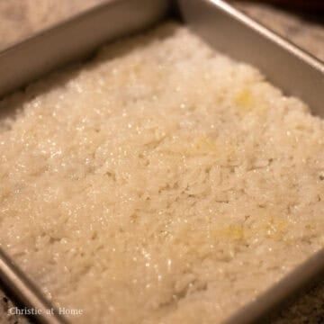 Then slide the white rice over the blue rice and pack down very well ensuring no cracks and holes. Smooth it out with spatula.