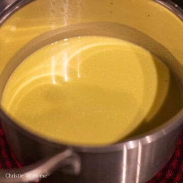 To make Pandan Custard Layer: add 10 pandan leaves and 200 ml or 6.76 fl oz of water into a blender and blend until smooth. Pour the content into a fine sieve and strain the liquids, discarding the pulp. Pour this pandan extract into a medium sized pot. Then whisk in the remaining pandan custard ingredients: cornstarch, all purpose flour, eggs, coconut milk, and sugar. Heat the pot on the stove over low-medium heat continually stirring until it thickens. Do not bring to a boil.