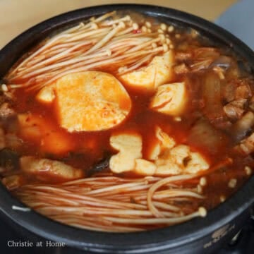 Add in enoki mushrooms in two bunches beside the tofu. Let this simmer for 1 minute.