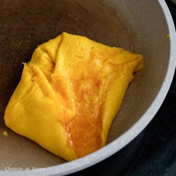 Heat 1 tablespoon vegetable oil in a small non-stick pan on low-medium heat. Pour in half the egg mixture and push it to one side of the pan to create a square shaped omelet until edges solidify. Then on the other side of the pan, pour the remaining egg mixture and cook it the same way.