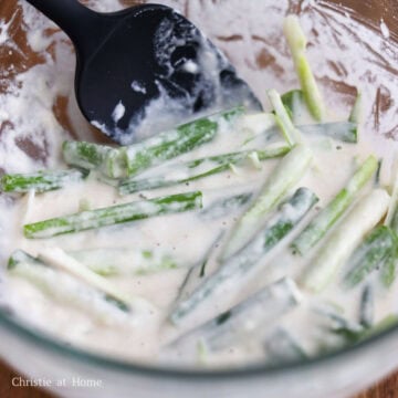 Whisking a light flour and starch batter in a large mixing bowl just until combined.