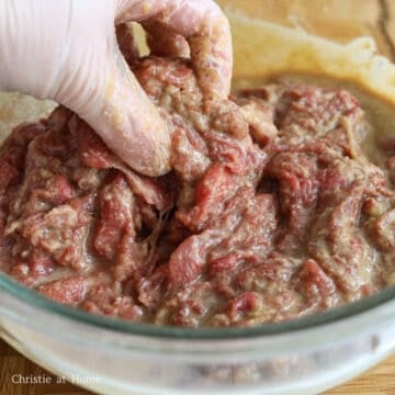 Thinly sliced raw beef thoroughly coated in a brown soy marinade.