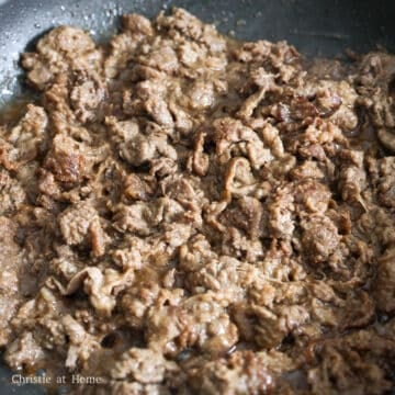 Searing thinly sliced marinated beef with caramelized brown edges.