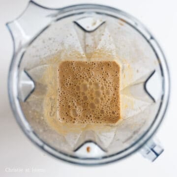 Smooth beige fruit and aromatic marinade purée in a blender.