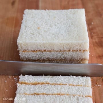 Three-layer peanut butter sandwich with the outer crusts trimmed off.