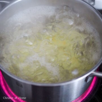 Large pot of potatoes boiling in water until fork-tender.