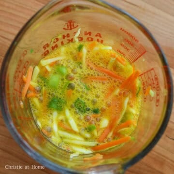 In a measuring cup with a lip or a small bowl, combine eggs, salt, cabbage, carrots and green onions and mix well. Set aside.
