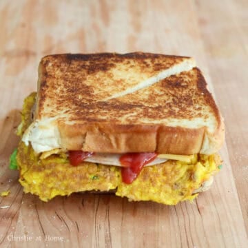 Close the sandwich with remaining slice of toast. Slice into half and enjoy hot!