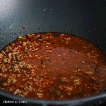 Next season meat with chicken bouillon powder, doubanjiang sauce, chili oil, dark soy sauce, sugar, and ground Sichuan peppercorn. Then mix in the chicken broth. Pour in the cornstarch slurry and allow the sauce to simmer and thicken.