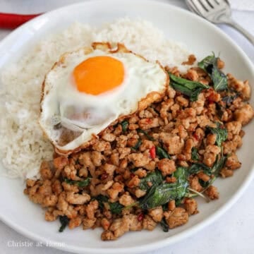 Pad kra pao served over steamed white rice with a crispy fried egg.