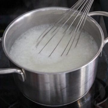 Congee whisked vigorously until the rice grains break down and become creamy.