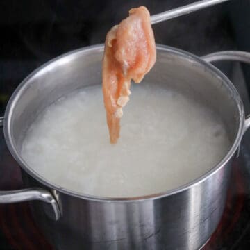 Marinated chicken, scallion whites, and ginger cooking in the congee.