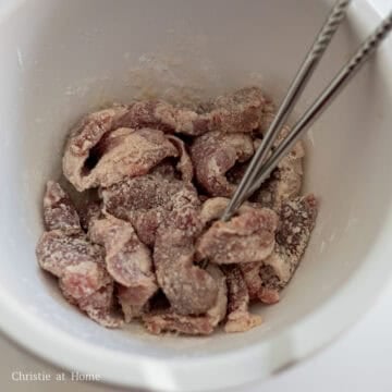 Pork shoulder pieces coated in cornstarch marinade.