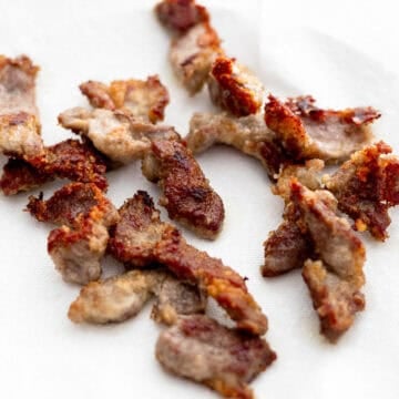 Golden fried pork pieces draining off excess oil.