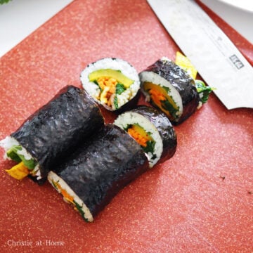 With a oiled knife, slice the kimbap into ½-inch thick pieces and enjoy! Repeat this process to create three more rolls.