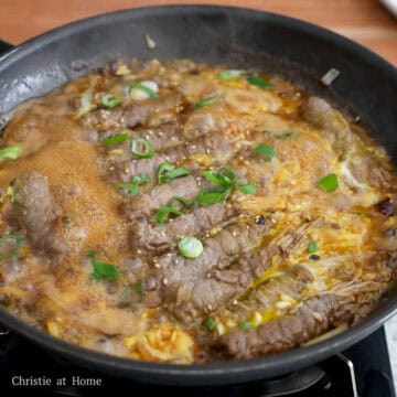 Beef enoki rolls cooked with eggs and garnished with green onions and sesame seeds