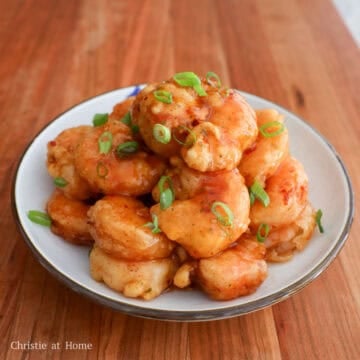 Transfer to a large mixing bowl. Pour the sauce over top. Gently toss to mix. Garnish with green onions. Enjoy hot!