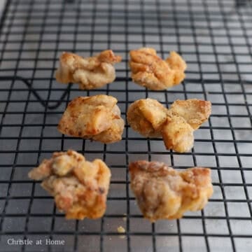 Crispy fried chicken draining on a wire rack.